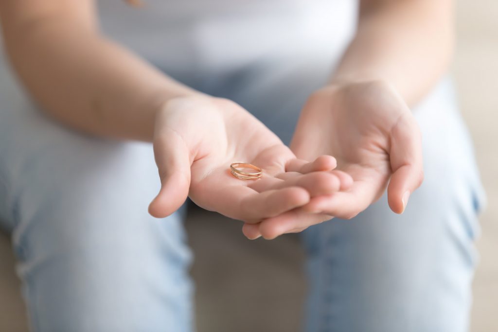 A person's Hands with a wedding ring symbolizes regret in their relationship reflecting the caution in Pre-Matrimonial Investigation.