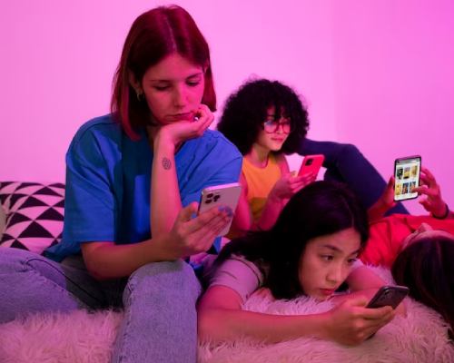 Three teenager girls engrossed in their smartphones seeking the best teenager monitoring services in pune