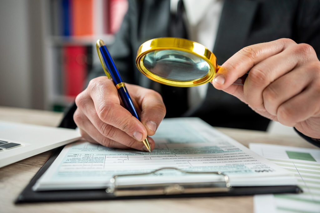 A meticulous professional doing research with a magnifying glass that indicates Post Matrimonial Investigation In Pune